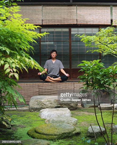 woman meditating in temple garden - karesansui stock-fotos und bilder