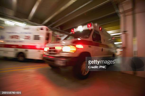 ambulance pulling away from hospital (blurred motion) - ambulance imagens e fotografias de stock
