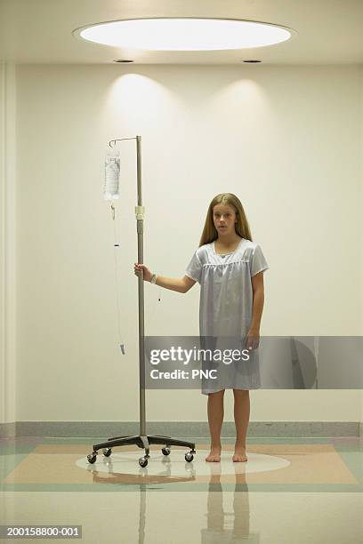 girl (11-13) standing in hospital corridor with iv drip, portrait - nightdress stock pictures, royalty-free photos & images