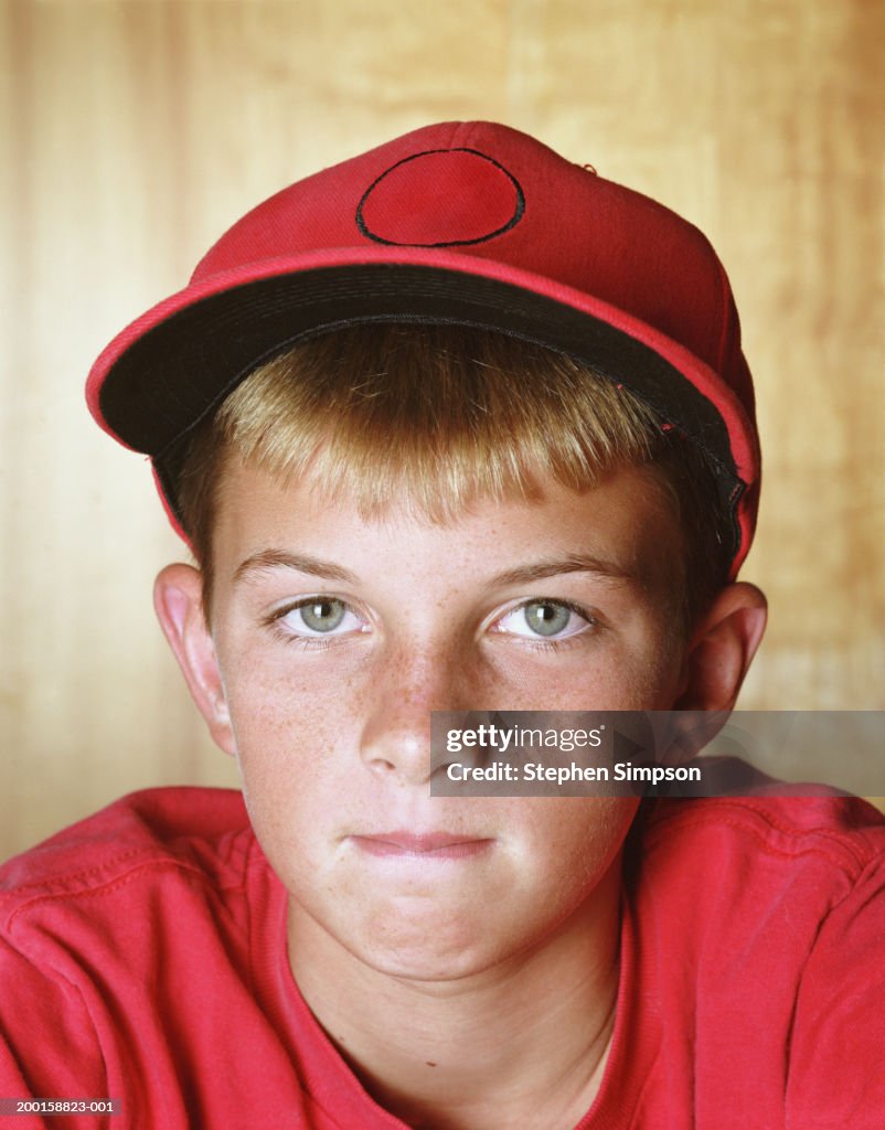 Boy (10-12) wearing red shirt and cap, portrait