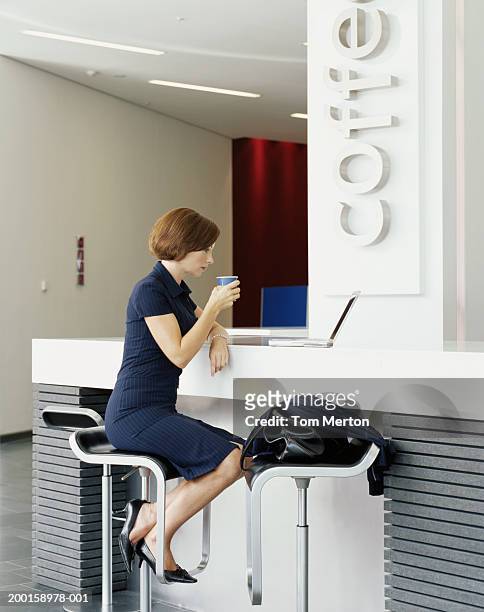 businesswoman at cafe counter, looking at laptop, profile - business frau profil kurze haare stock-fotos und bilder