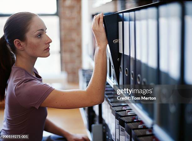 Folder R Pull Woman Pulling Folder Off Shelf Of Folders Closeup High-Res Stock Photo ...