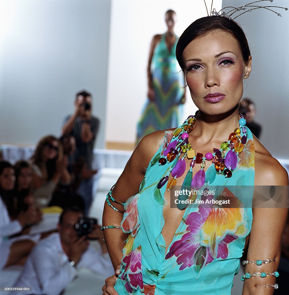 Fashion models walking on catwalk (focus on woman in foreground)