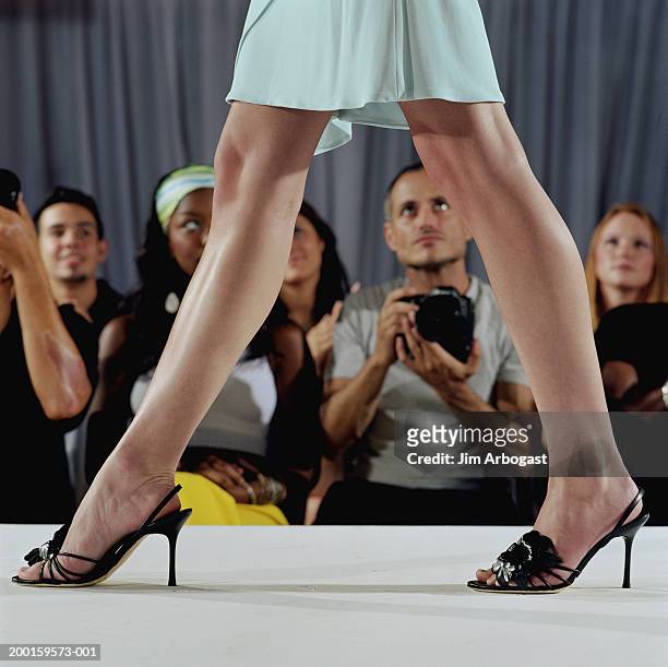 fashion model walking on catwalk, audience in background, low section - leg show fotografías e imágenes de stock