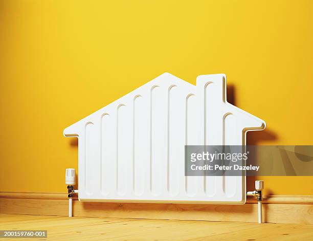 house shaped radiator on wall - calor fotografías e imágenes de stock