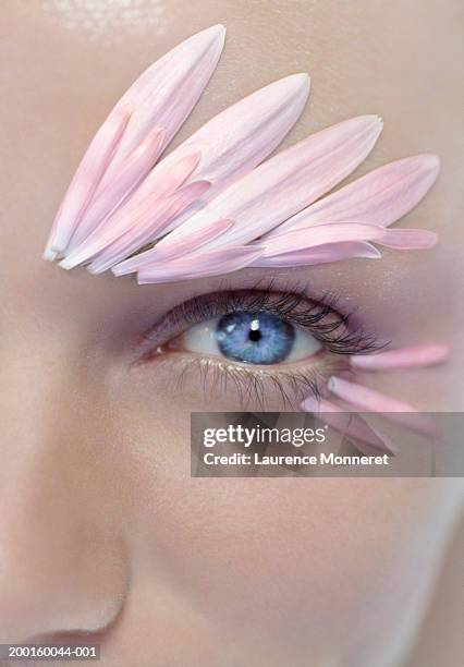 young woman with petals above and below eye, portrait, close-up - wimper stockfoto's en -beelden