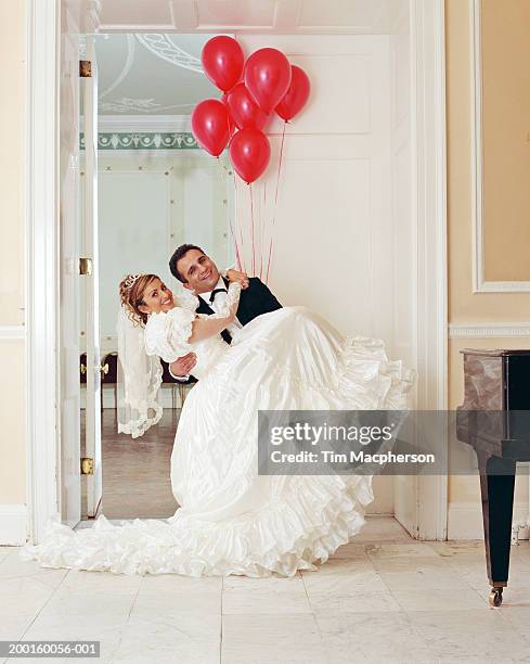 groom lifting bride, smiling, portrait - stoneplus8 stock pictures, royalty-free photos & images