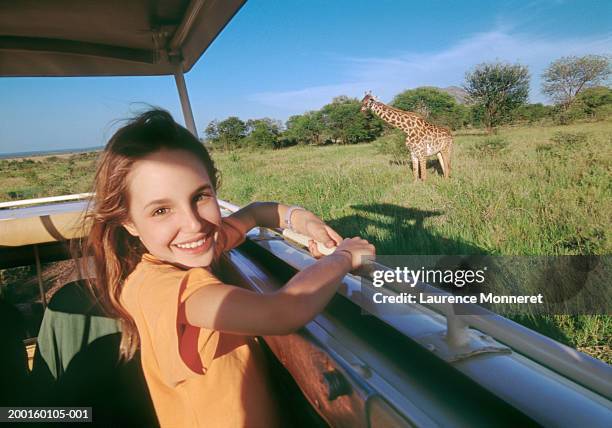 girl (10-12) on safari bus, giraffe in background, portrait - travel11 stock pictures, royalty-free photos & images