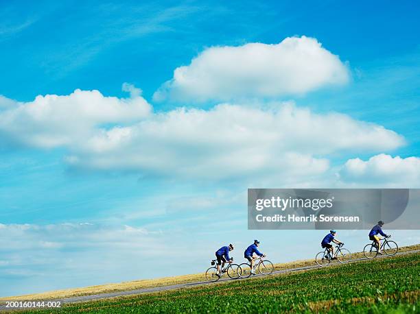 four senior men cycling up hill, side view - só homens idosos imagens e fotografias de stock
