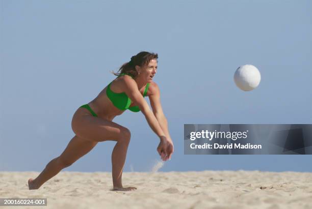 woman playing beach volleyball - spiking stock-fotos und bilder