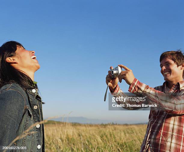 man taking digital photograph of young woman, laughing - cabeça para trás - fotografias e filmes do acervo