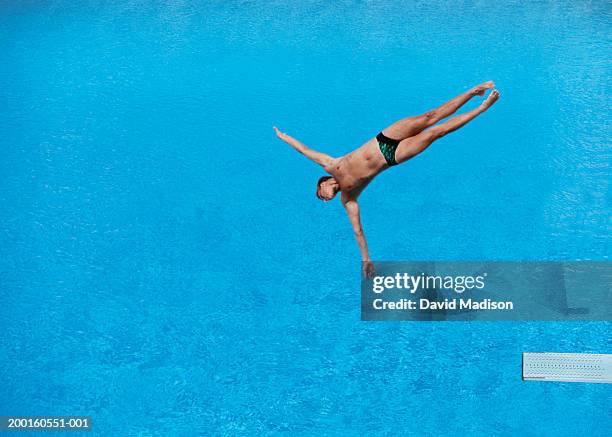 male diver in mid-air, elevated view (digital enhancement) - slip de bain de compétition photos et images de collection