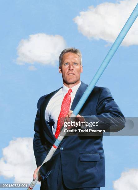 businessman running with pole towards crossbar (digital composite) - pole vault stock pictures, royalty-free photos & images