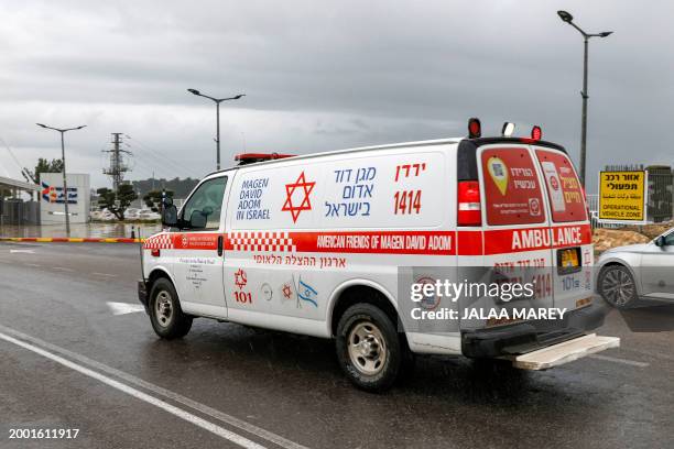 An ambulance vehicle moves along a road towards the entrance of Ziv hospital in Israel's northern city of Safed on February 14 near the scene of...