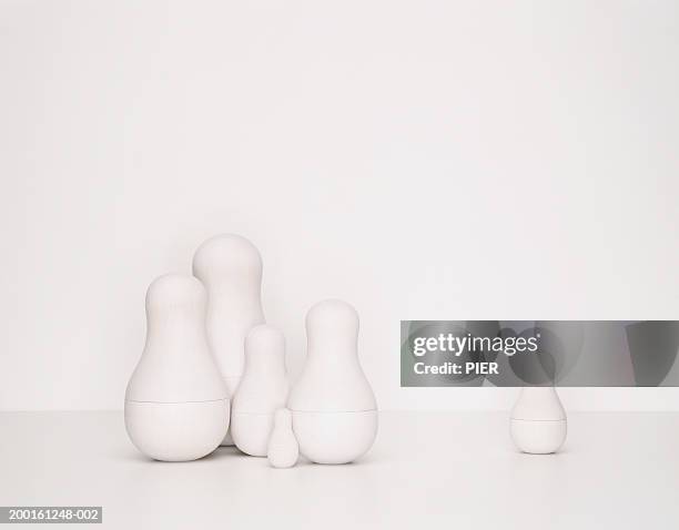 set of undecorated russian dolls, one separated from group - mamushka fotografías e imágenes de stock
