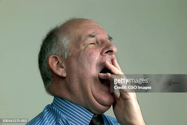 mature businessman yawning, eyes closed, close-up - boring portrait imagens e fotografias de stock