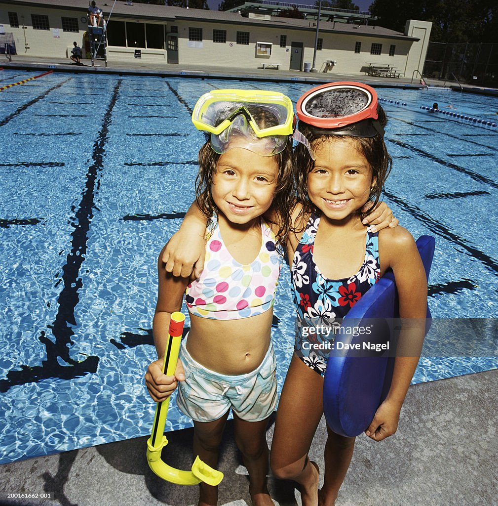 Twin girls (6-8) with swimming gear, portrait