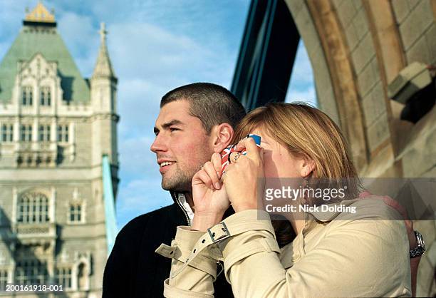 couple outdoors, woman taking photograph with disposable camera - travel11 stock pictures, royalty-free photos & images