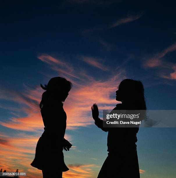 two girls (5-7) playing, dusk, silhouette - stoneplus8 stock pictures, royalty-free photos & images