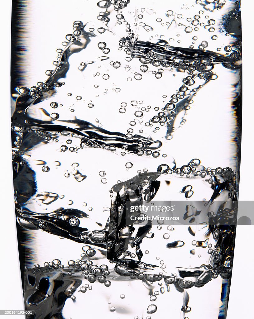 Ice cubes in glass of fizzy drink, detail