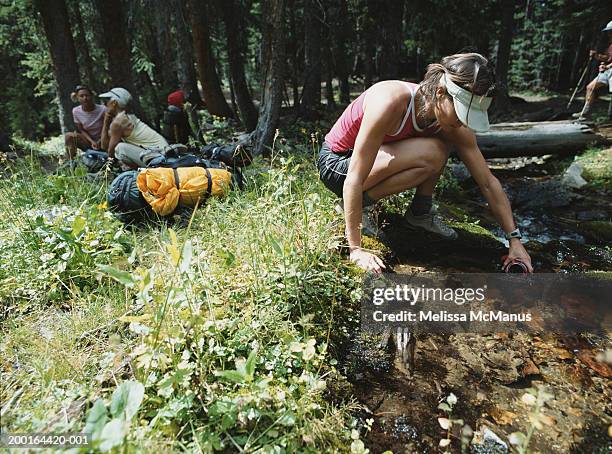 woman getting water from stream - travel12 stock pictures, royalty-free photos & images