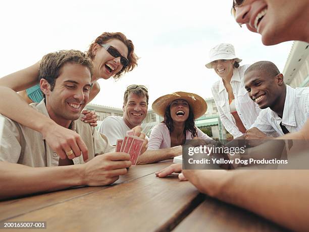 group of adults playing cards by poolside of hotel - toy adult stock pictures, royalty-free photos & images