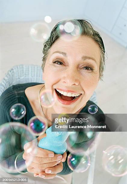mature woman below soap bubbles, smiling, portrait, close-up - bubbles happy fotografías e imágenes de stock