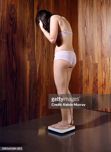 young woman wearing underwear, standing on scales - stoneplus8 stock pictures, royalty-free photos & images
