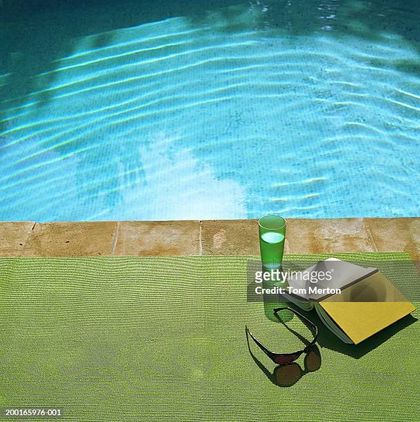 drink, book and sunglasses on beach mat at edge of swimming pool - travel12 stock pictures, royalty-free photos & images