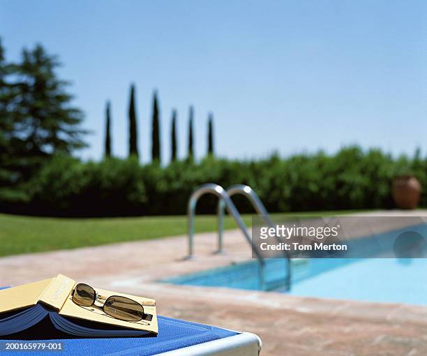 book and sunglasses on sun lounger (focus on book and sunglasses) - travel12 stock pictures, royalty-free photos & images