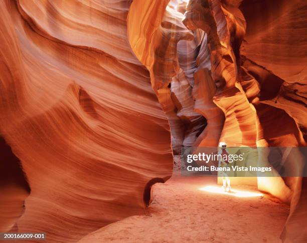 man in canyon in sun spot, looking up - monument valley stockfoto's en -beelden