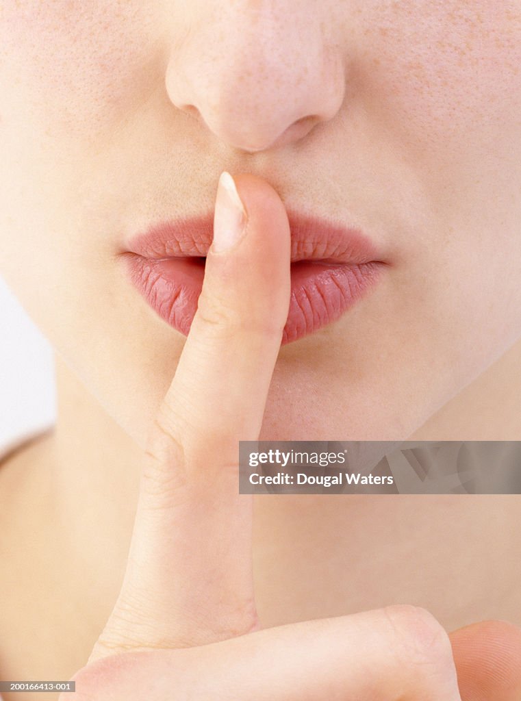 Young woman with finger on lips, detail