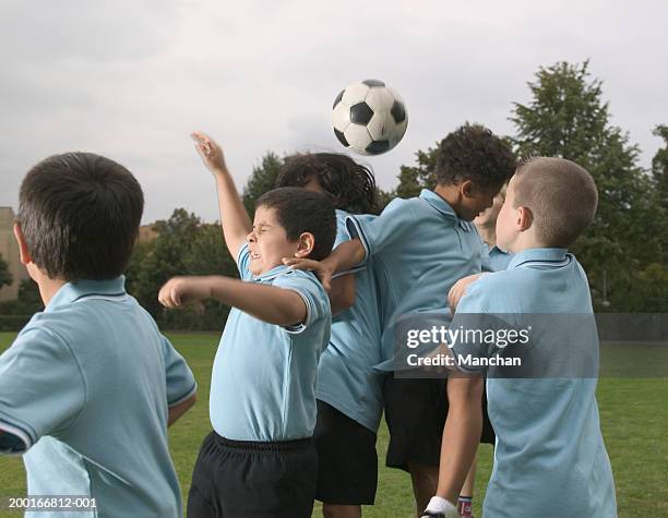 group of children (7-9) playing football - youth football team stock pictures, royalty-free photos & images