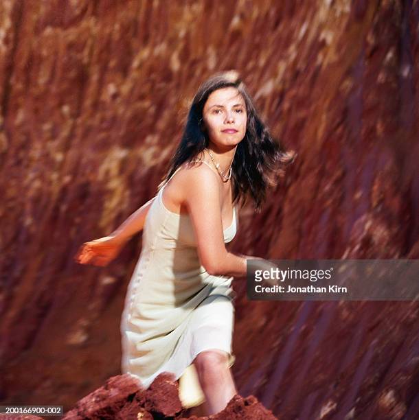 young woman running up red dirt hill (blurred motion) - red dress run stock pictures, royalty-free photos & images