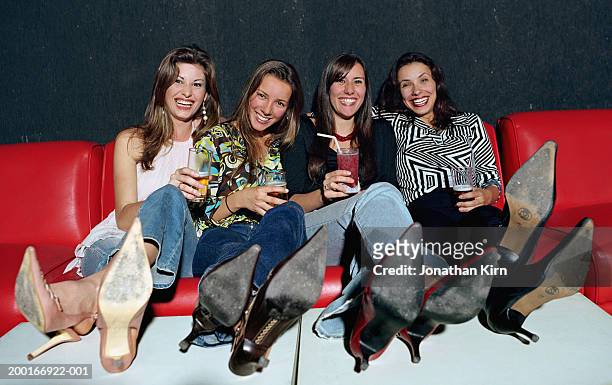 four young women in nightclub holding drinks, portrait - kitten heel stock pictures, royalty-free photos & images