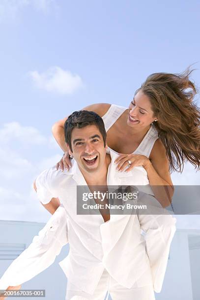 man carrying woman piggyback near pool - heteroseksueel koppel stockfoto's en -beelden