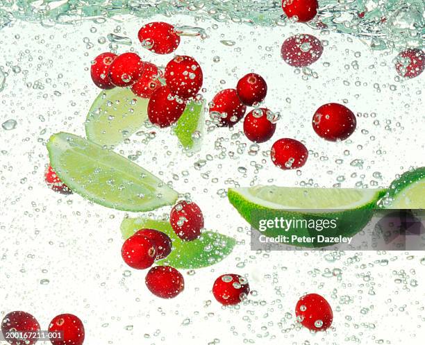 cut lime and cranberries in sparking water, detail - cranberry stock pictures, royalty-free photos & images