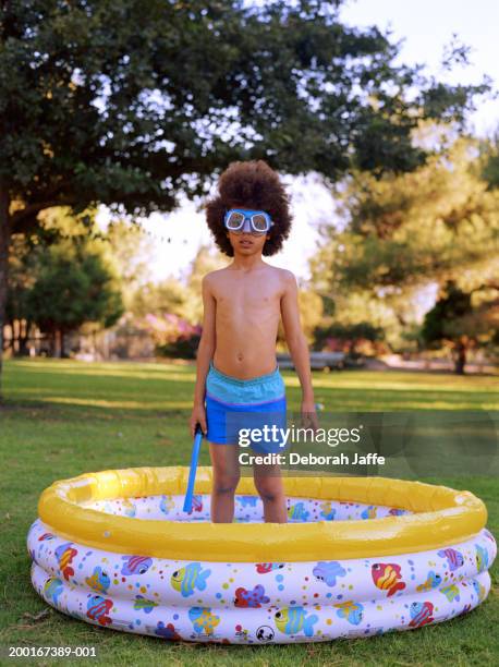 boy (7-9) wearing goggles, standing in paddling pool - inflatable stock pictures, royalty-free photos & images