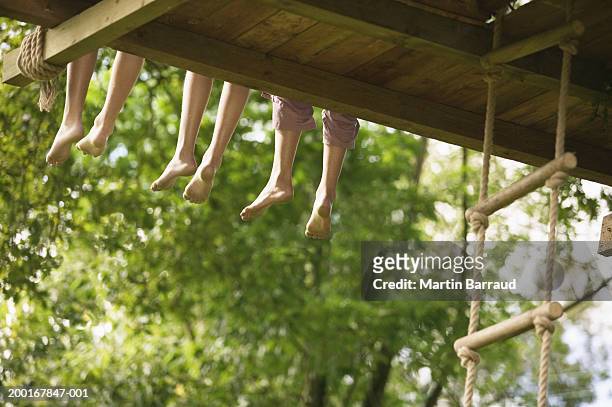 three children (9-12) sitting at edge of treehouse, low section - tree house stock pictures, royalty-free photos & images