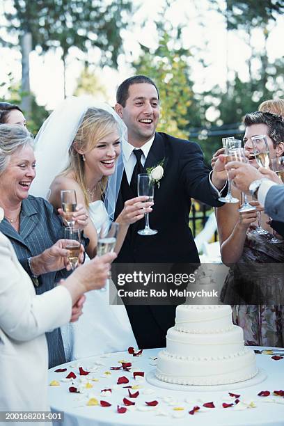 bride, groom and guests raising toast with champagne at reception - front on groom and bride stock pictures, royalty-free photos & images