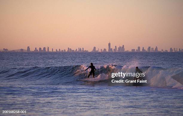 two people surfing at sunset - brisbane bildbanksfoton och bilder