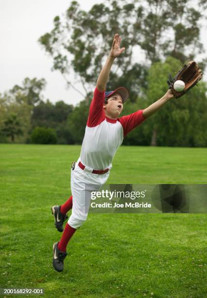 boy (10-12) lunging forward to reach baseball - baseball glove stock pictures, royalty-free photos & images