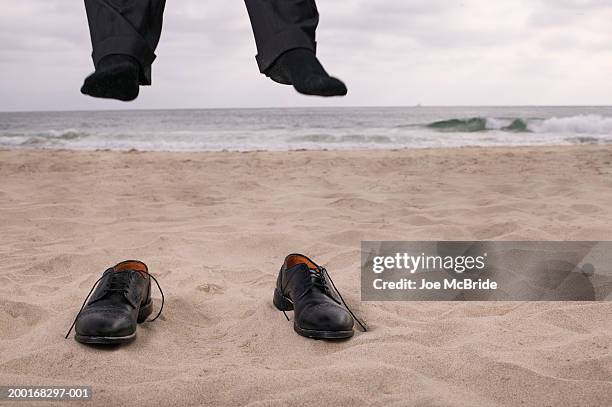 businessman jumping on beach, shoes in sand - odd socks stock pictures, royalty-free photos & images