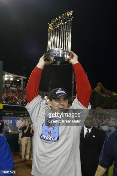 Tim Salmon of the Anaheim Angels holds the World Series trophy above his head as he circles the field after the victory over the San Francisco Giants...