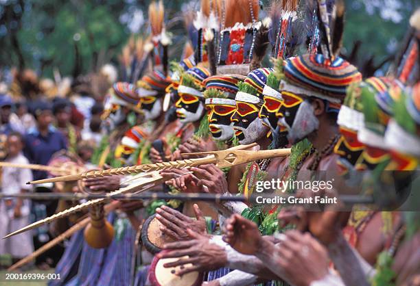 group of men in tribal costume, side view - goroka stock-fotos und bilder