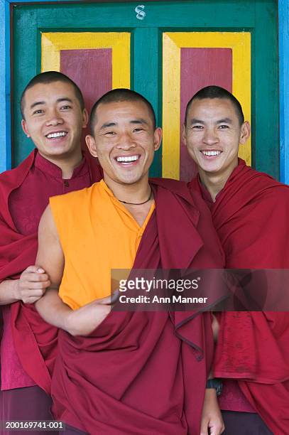 bhutan, jakar, three monks standing side by side, smiling, portrait - bhutan stock pictures, royalty-free photos & images