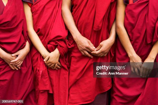 bhutan, four monks standing side by side, hands clasped, mid section - bhoutan photos et images de collection