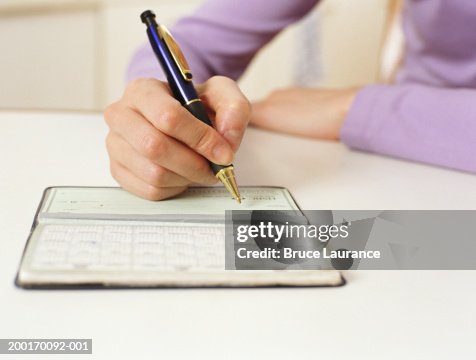 Woman Writecheck Woman Writing In Checkbook Closeup High-Res Stock Photo - Getty Images