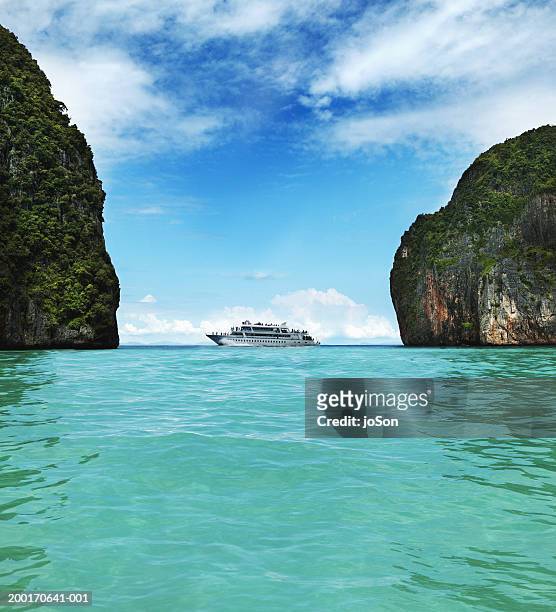 cruise ship between two large limestone rocks - cruise liner stock pictures, royalty-free photos & images