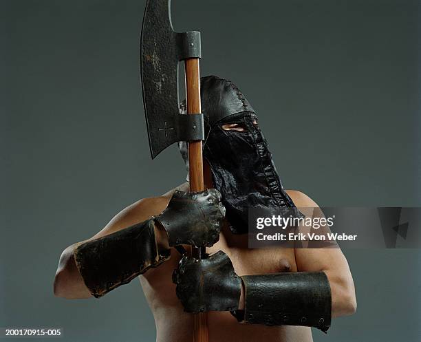 man wearing leather helmet and mask holding ax - executioner stock pictures, royalty-free photos & images